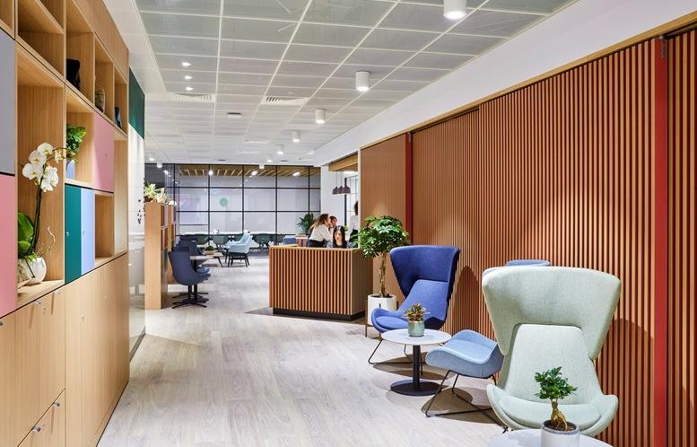 Spacious reception area at Building 4, Uxbridge Business Park, Sanderson Road with wooden walls and colorful chairs.