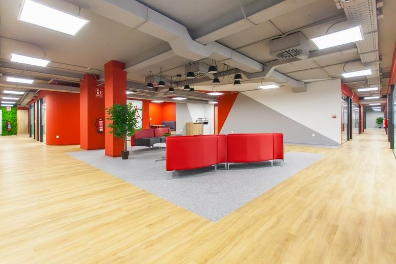 Spacious communal lounge at C/ Edgar Neville, 3, Madrid featuring modern red seating and wood-style flooring.