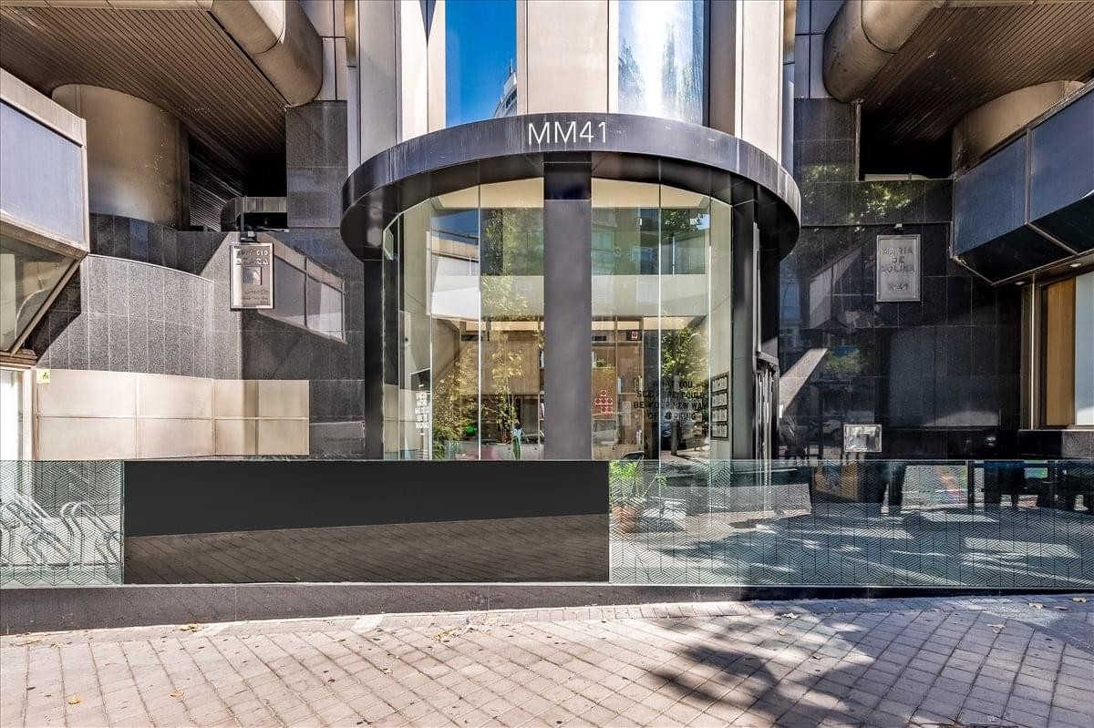 Ground level exterior view of the modern glass entrance at C/ María de Molina 41.
