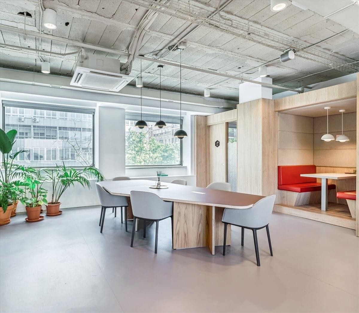 Modern exterior of the curved glass entrance at C/ María de Molina 41.