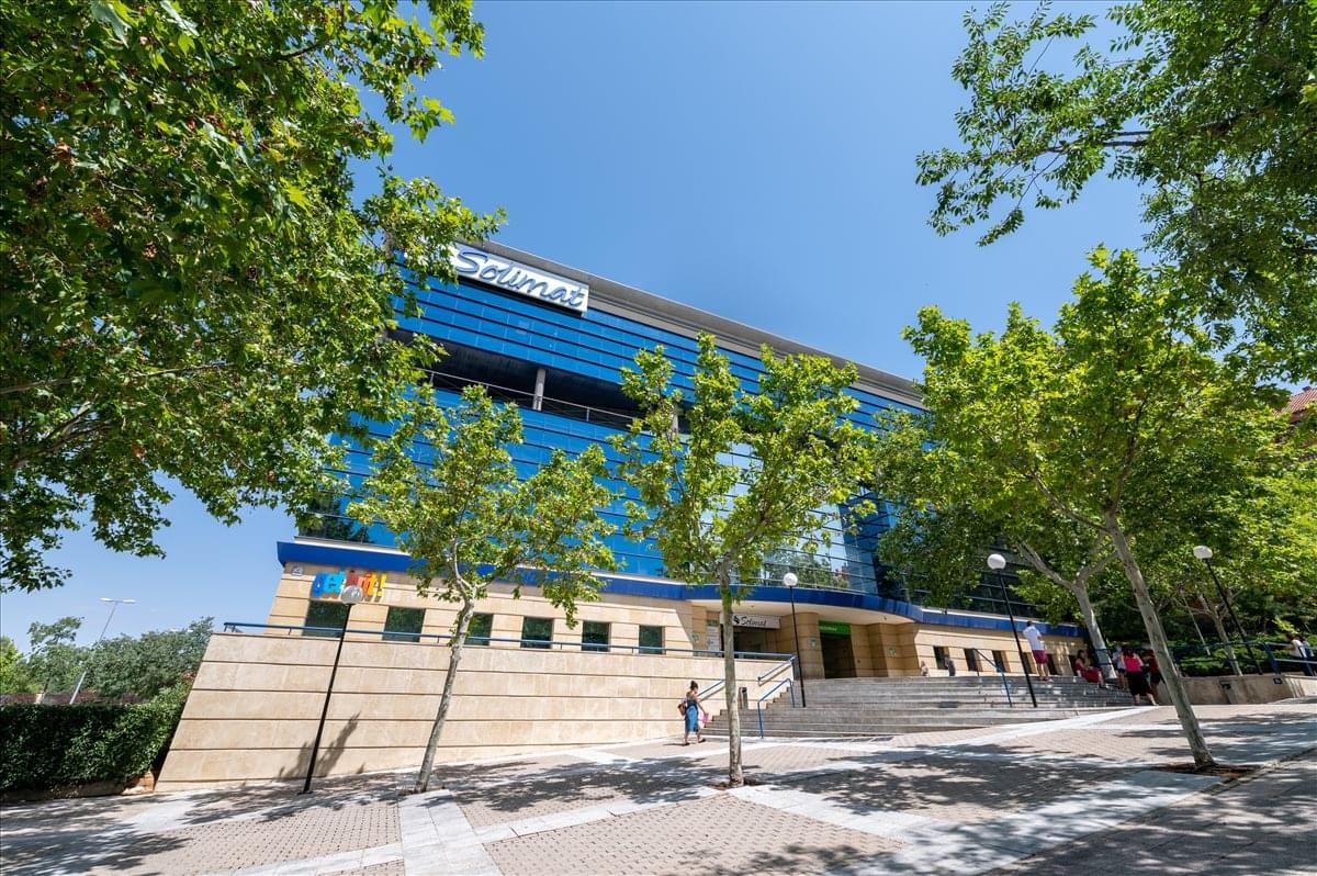 Exterior view of the blue glass-facade building at Calle Berna nº1, planta 1, Toledo.