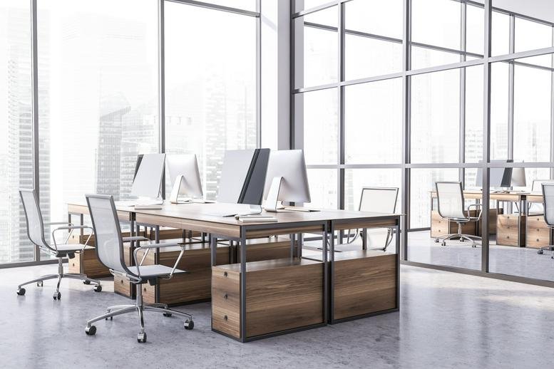 Bright, modern workstations with wooden desks and glass partitions.