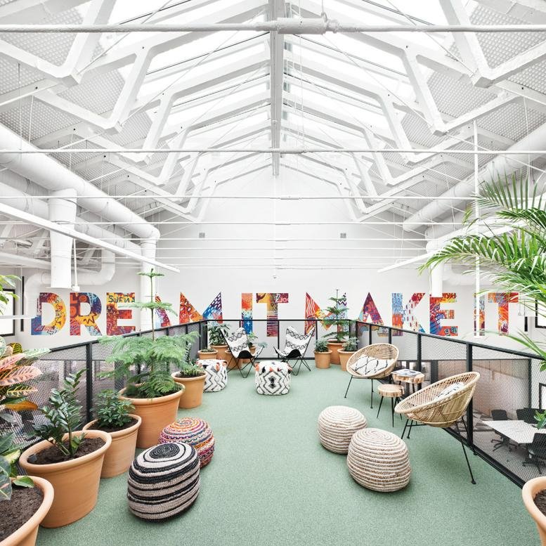 Spacious, sunlit communal lounge at Calle Don Ramón de la Cruz, 38 with vaulted skylights and colorful wall art.