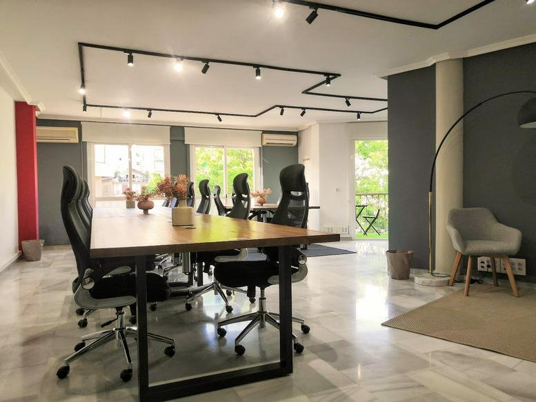 Spacious wood-topped conference table with ergonomic chairs at the Calle Puerto 14, Malaga office workspace.