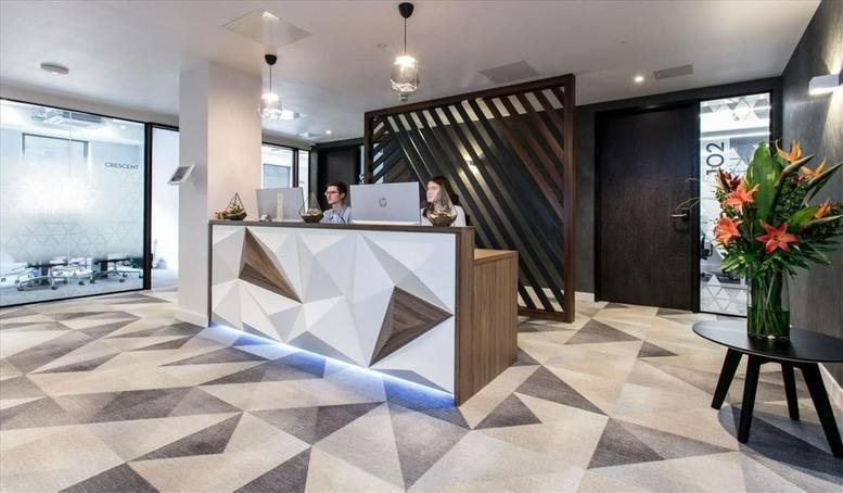 Modern reception area of Cambridge House, Henry Street, Bath, with geometric patterns and warm lighting.