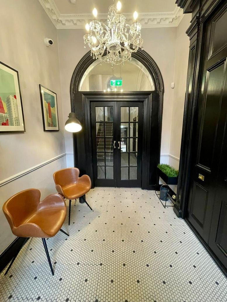 Grand reception at Carmichael House, 60 Lower Baggot Street featuring a chandelier and arched doorway.