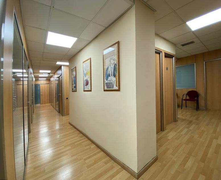 Bright hallway at Carrer De La Marina, 148-150 Entresuelo 3ª with light wood floors and framed art.