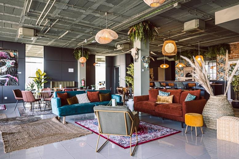 Spacious communal lounge at Carrer Santa Coloma, 99, Girona, Barcelona with colorful sofas and eclectic decor.