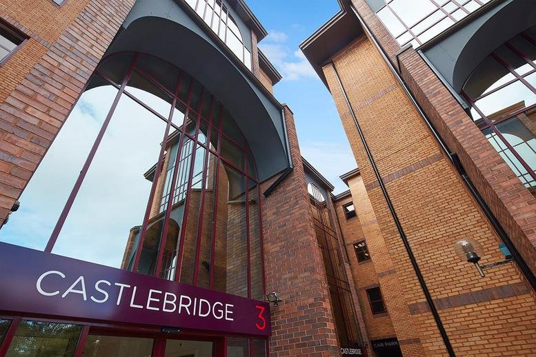 Low-angle exterior view of the brick and glass facade at Castlebridge, Cardiff.