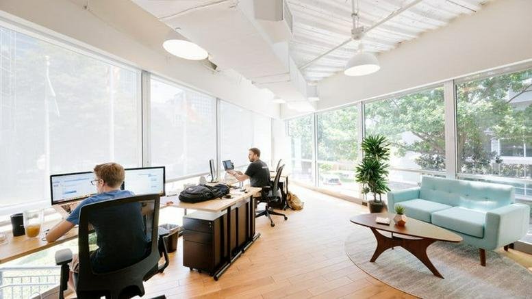 Bright open-plan workspace at Charlemont Exchange, 42 Charlemont Street, Dublin with large windows and a mint green sofa.
