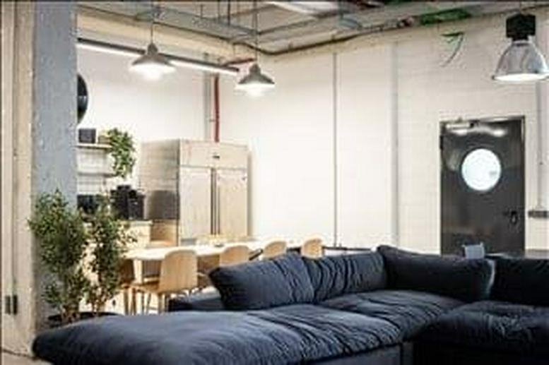 Spacious communal lounge at Charlottenburger Straße 62 with a large blue sectional sofa and dining area.