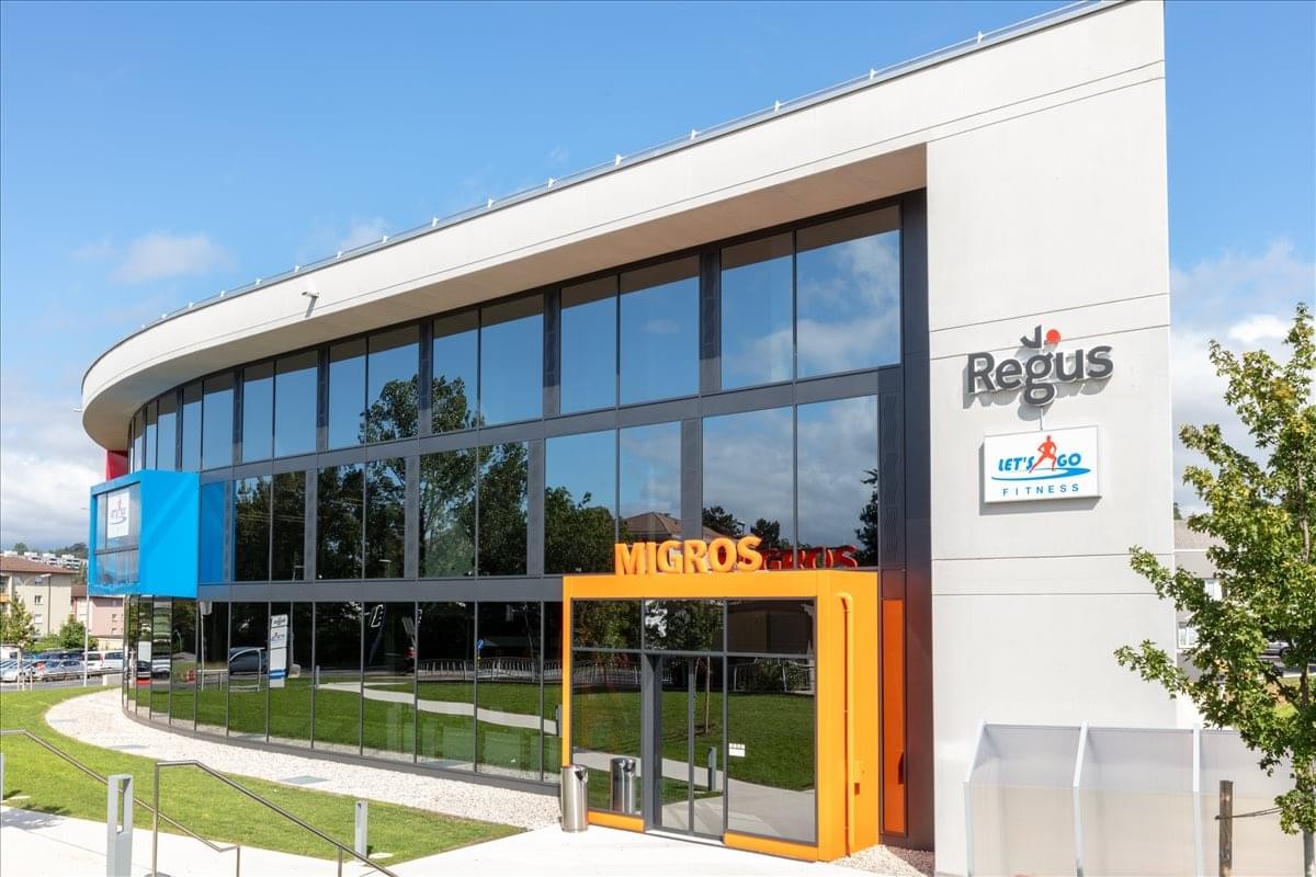 Exterior view of the modern curved glass building at Chemin du Vuasset 2, Préverenges.