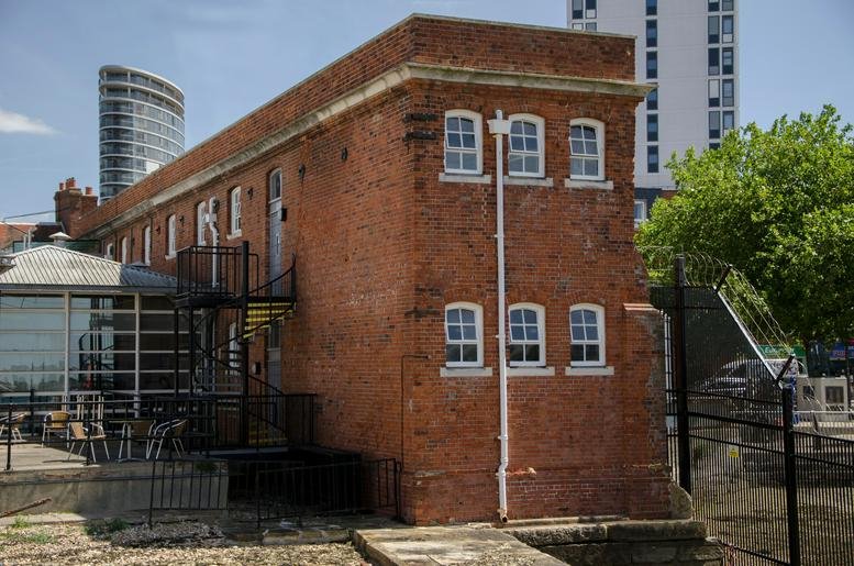 Exterior view of the historic red brick Cell Block Studios building with large modern windows.