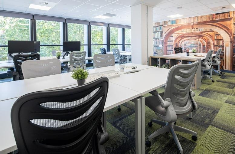 Spacious open-plan workspace at Beacon Tower, Colston Street with modern grey chairs and large windows.