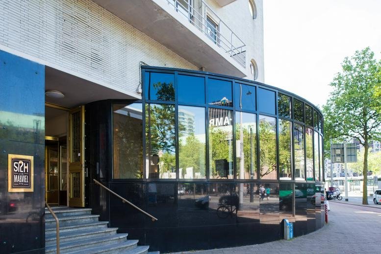 Ground level exterior view of the glass-facade building at Coolsingel 104, Rotterdam.