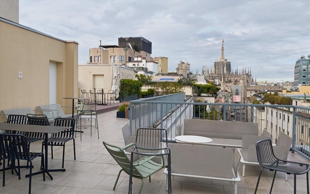 Outdoor rooftop terrace at Corso Europa 15, Milan, Italy with modern seating and city views.
