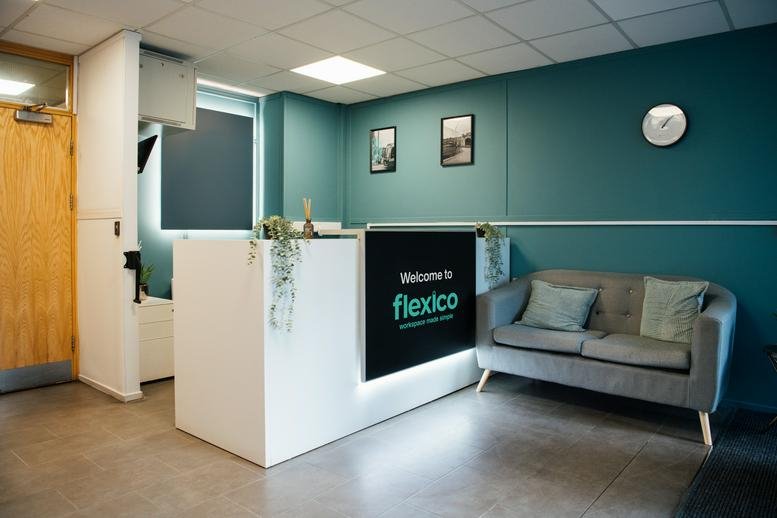 Modern reception area of Courtwood House, Silver Street Head with a teal feature wall and grey sofa.