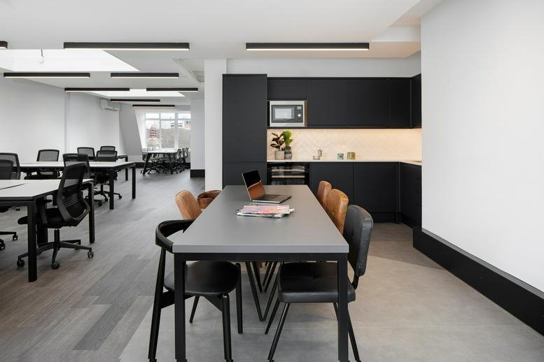 Spacious communal breakout area at Cromwell House, 14 Fulwood Place, featuring a long dining table and kitchen.