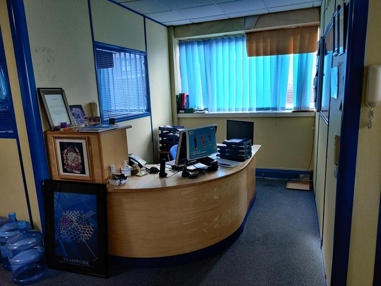 Wooden reception desk at Cygnus Business Centre, Dalmeyer Rd, Unit 28 with blue window blinds.
