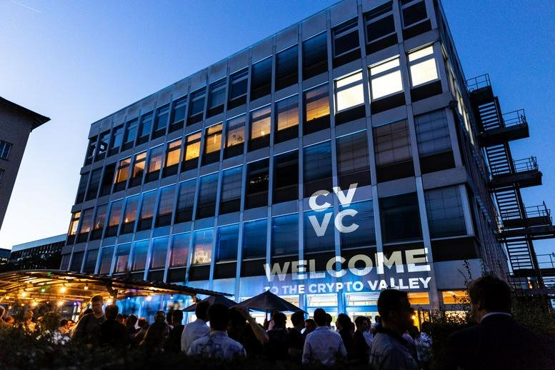 Exterior view of the CV VC building at Dammstrasse 16, Zug, Switzerland at dusk with event lighting.