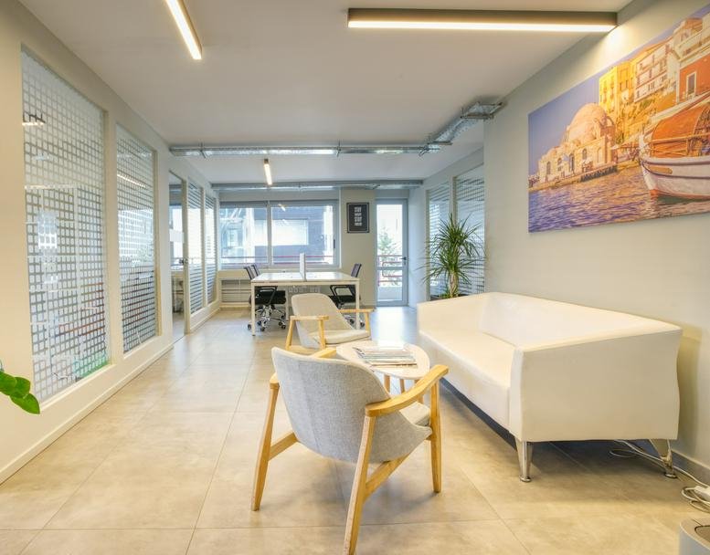 Bright lobby at Dimitriou Gounari 96 & Kifisias, 1st & 3rd Floors, Maroussi with white sofa and colorful art.