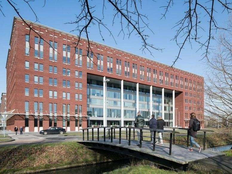 Exterior view of the red brick and glass facade of the Domus Medica building in Utrecht.
