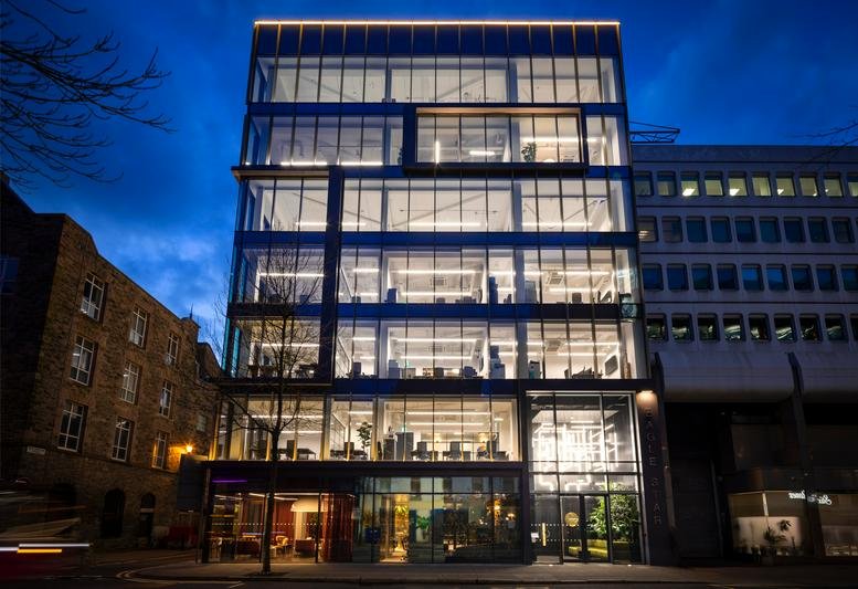 Exterior view of the modern glass-fronted Eagle Star House, 5-7 Upper Queen Street, Belfast at dusk.