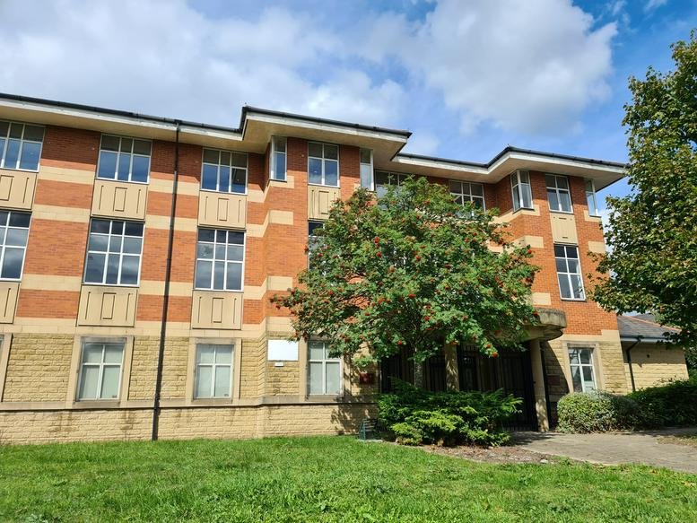 Exterior view of the brick facade and entrance of Castle House in Accrington.