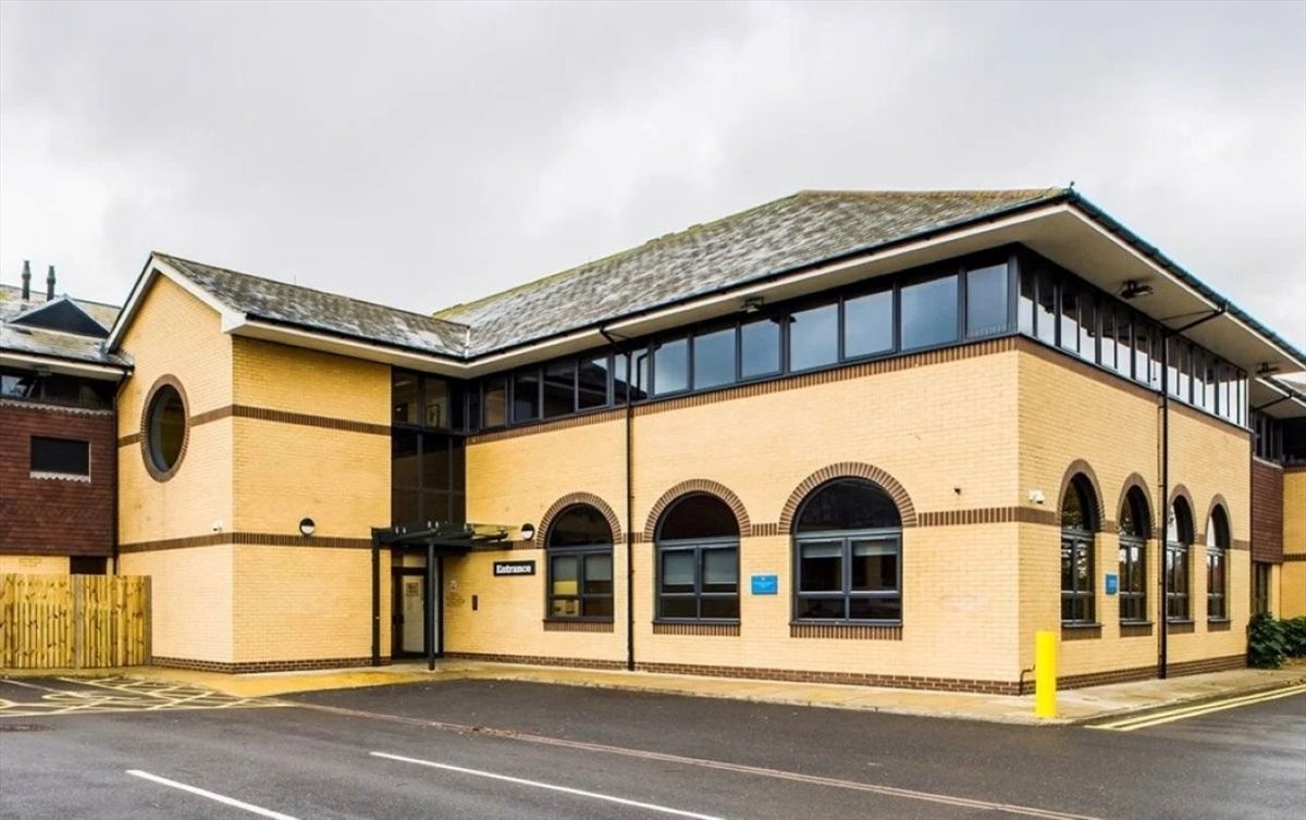 Exterior view of the tan brick Enterprise Hub building with arched windows in West Sussex.