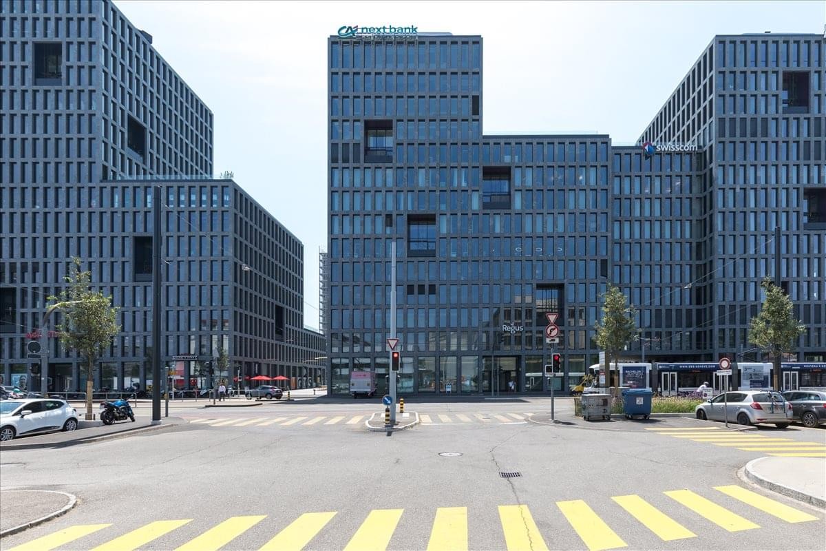 Exterior view of the modern glass-facade buildings at Esplanade de Pont-Rouge 4, Geneva.