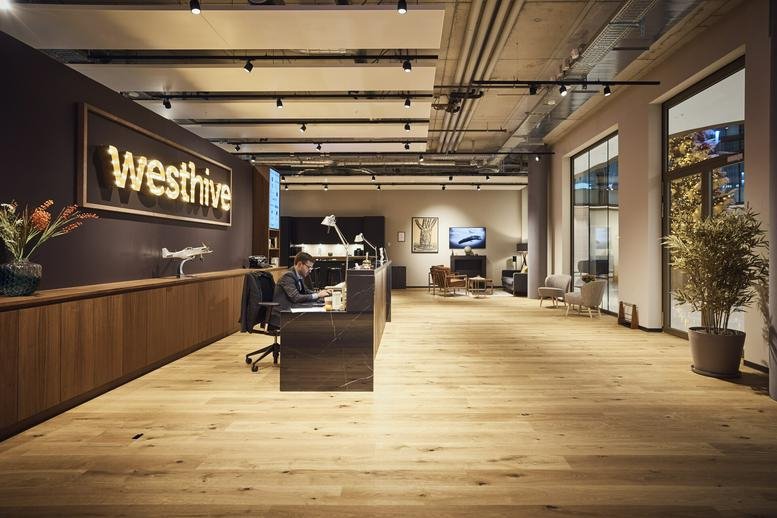 Spacious reception area at Esplanade De Pont-Rouge 9A with wooden floors and branded signage.