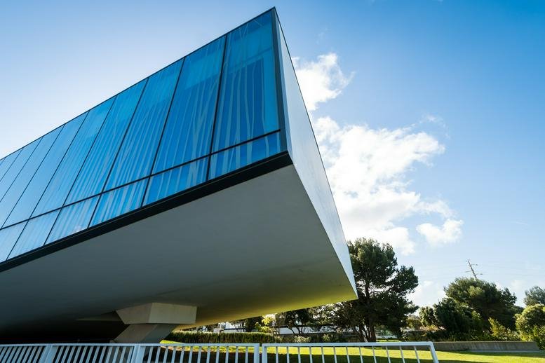 Exterior view of the striking cantilevered glass facade at Estrada da Malveira Serra 920.