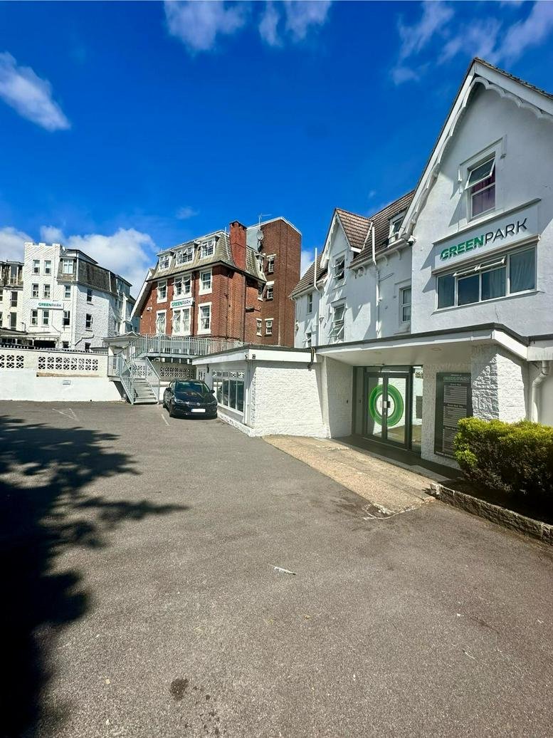 Exterior entrance of Bourne Gardens showing the white facade and Greenpark signage.