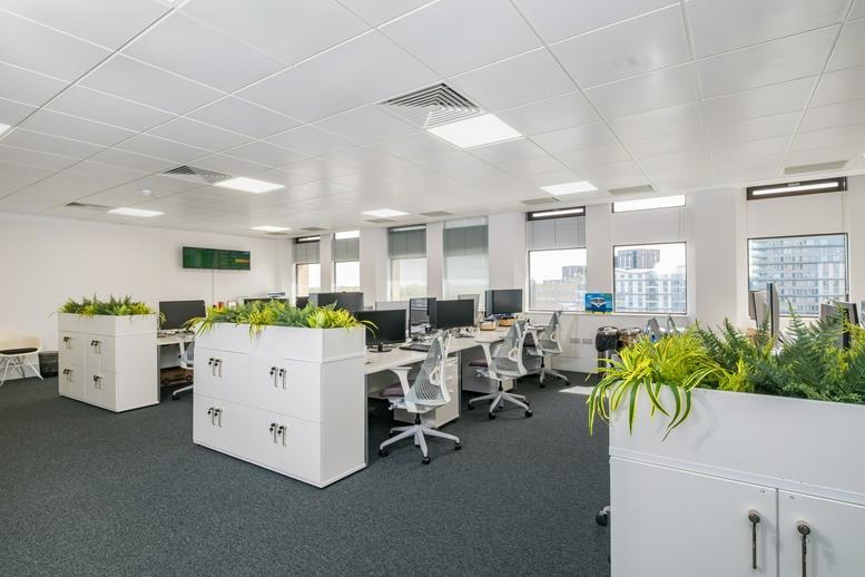 Spacious open-plan office area at Export House, Cawsey Way, with white desks and vibrant indoor plants.