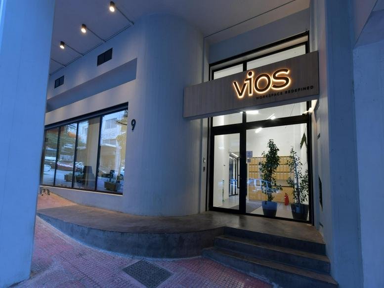 The modern glass and concrete entrance of Feidiou 9, Athens, Greece at dusk.