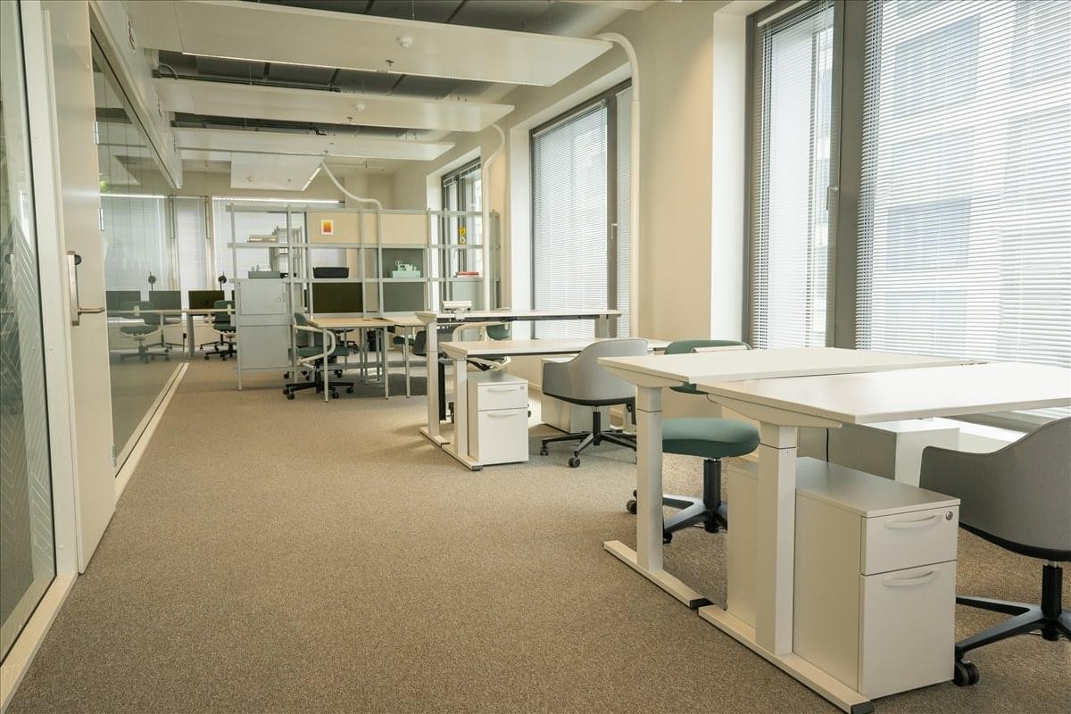 Spacious open-plan office at Firdonkatu 2 with height-adjustable desks and large windows.
