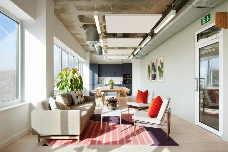 Spacious sunlit lounge at Fivefields, 8-10 Grosvenor Gardens with a beige sofa and red accents.