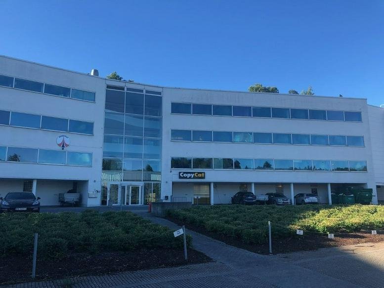 Exterior view of the white facade and glass entrance at Fornebuveien 1-3, Lysaker.
