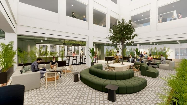 Spacious communal atrium at Foundry, 6 Brindley Place, featuring green curved seating and a central tree.