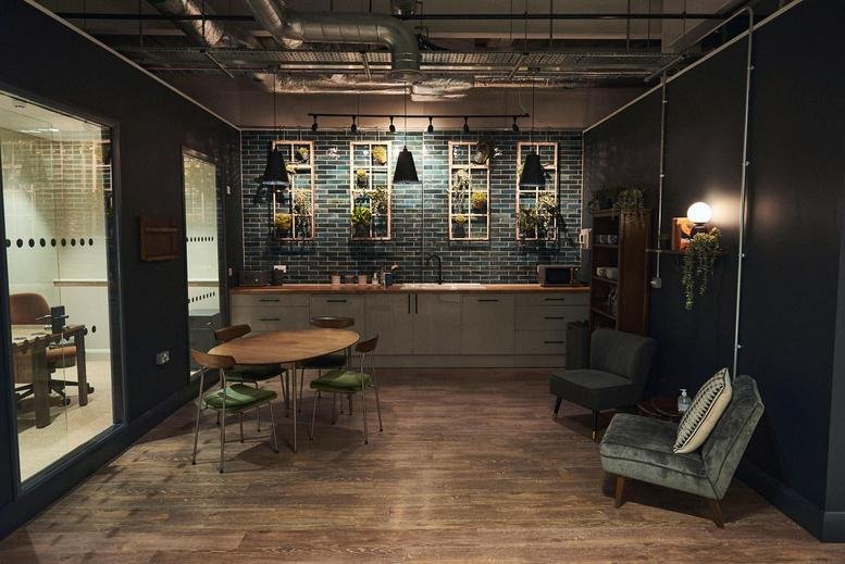 Spacious communal lounge at Franklins House, Wesley Lane, with industrial ceilings and warm wood floors.