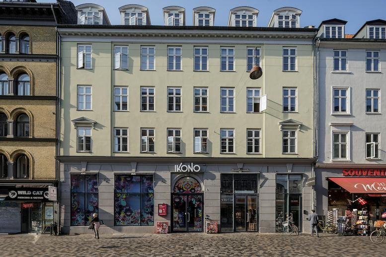 Exterior view of the classic yellow building facade at Frederiksborggade 5, Copenhagen.
