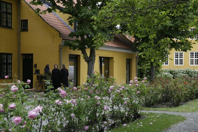 Exterior view of the yellow building and rose gardens at Frederiksholms Kanal 30, København K.
