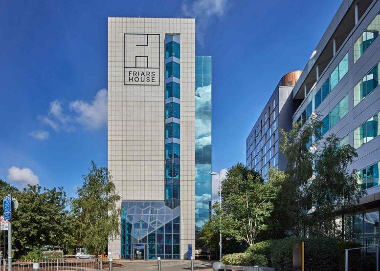 Exterior view of the multi-story glass and light-stone facade of Friars House.