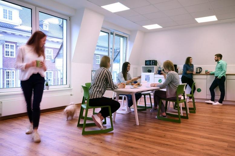 Spacious communal dining area at Friedrich-Ebert-Straße 33 with wooden floors and people socializing.