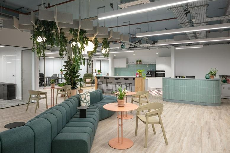 Spacious communal lounge at Fulham Broadway Centre with green velvet seating and hanging plants.