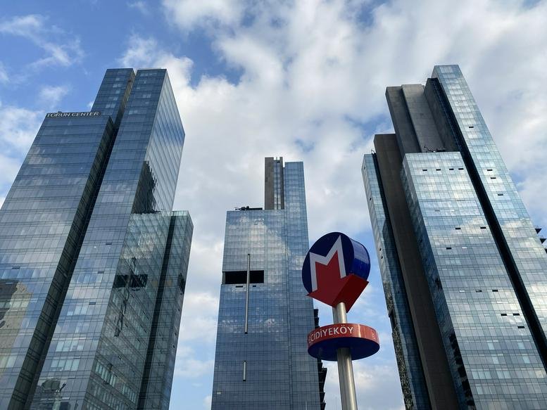 Exterior view of the glass-facade Torun Center towers against a blue sky.