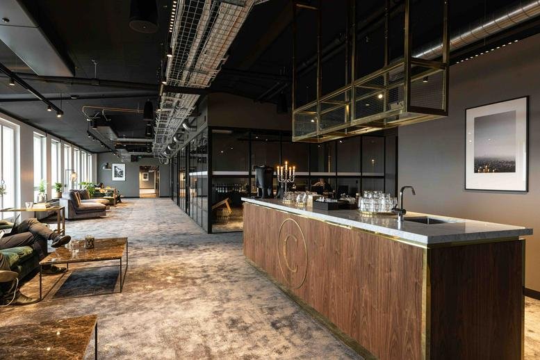 Spacious communal lounge and kitchen at Gävlegatan 16, Stockholm with dark ceilings and wood finishes.