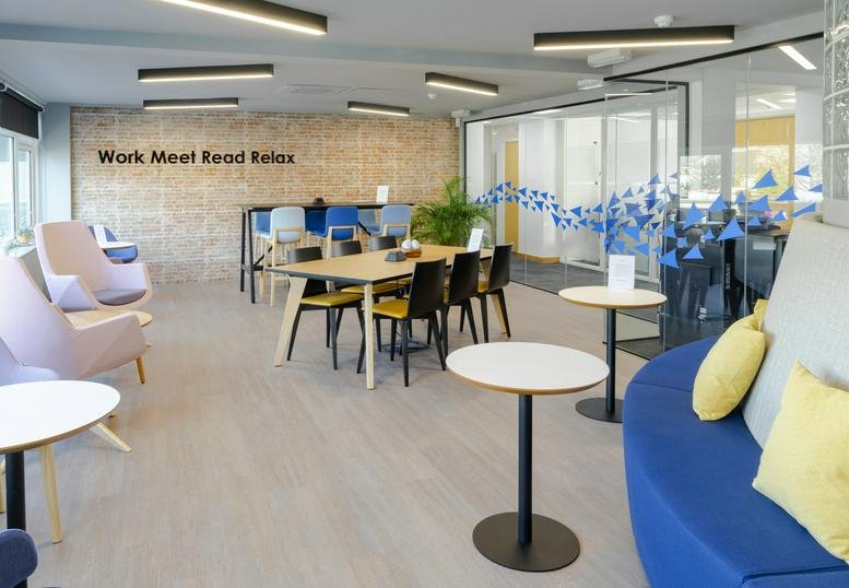 Vibrant lobby area with blue and yellow soft seating and modern pendant lighting.