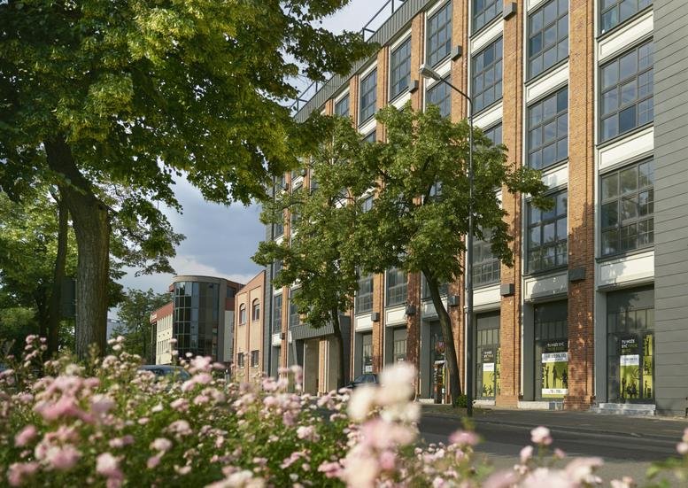 Exterior view of the red brick and glass industrial building at Gdańska 130, Lodz, Poland.