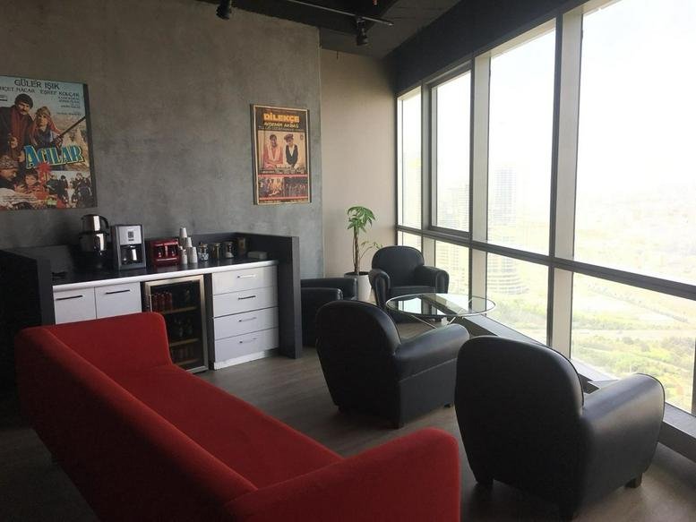 Lounge area with red sofa and floor-to-ceiling windows at Ofisim Kayseri B Blok Kocasinan/Kayseri.